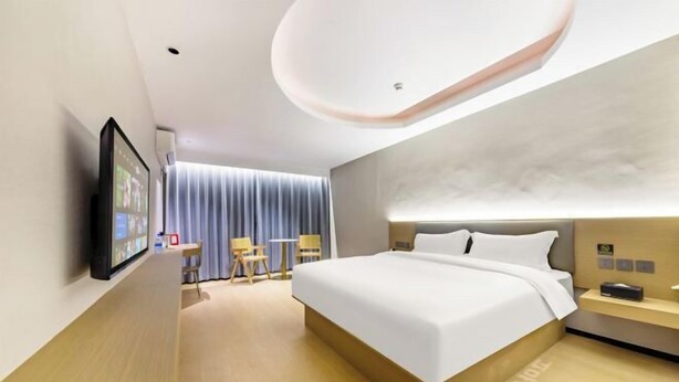 A modern hotel room with a large bed, a desk, a chair, and a television. - Shankee Chain Hotel (Zhuhai Jing'an Bridge) (Zhuhai)