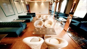 Ein stilvoller Lounge-Bereich mit einem zentralen Tisch, bequemen Sitzgelegenheiten und Holzboden.