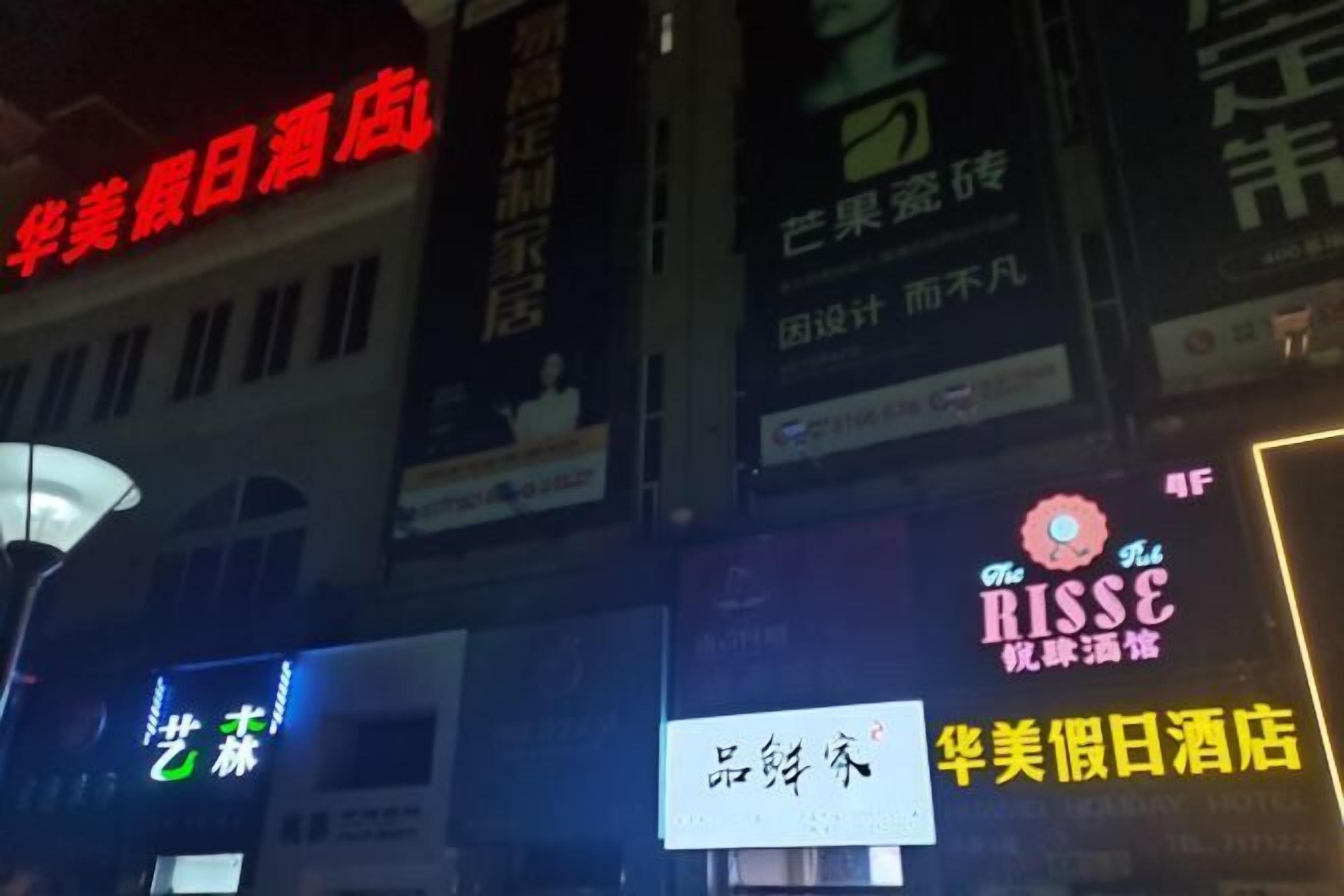 A hotel with multiple signs in a foreign language, indicating it is a hotel.
