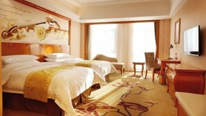 A hotel room with a large bed, a desk, a chair, and a television. - Vienna International Hotel (Jilin Guotou Zhongdong) (Jilin City)