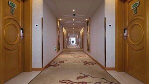 A hotel hallway with wooden doors, numbered room signs, and a carpeted floor. - Vienna International Hotel (Jilin Guotou Zhongdong) (Jilin City)
