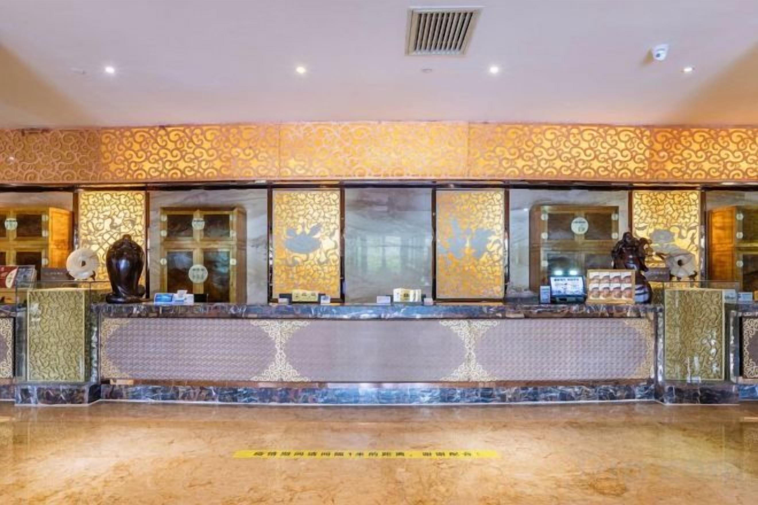 A reception area with a patterned wall, a reception desk, and a tiled floor.