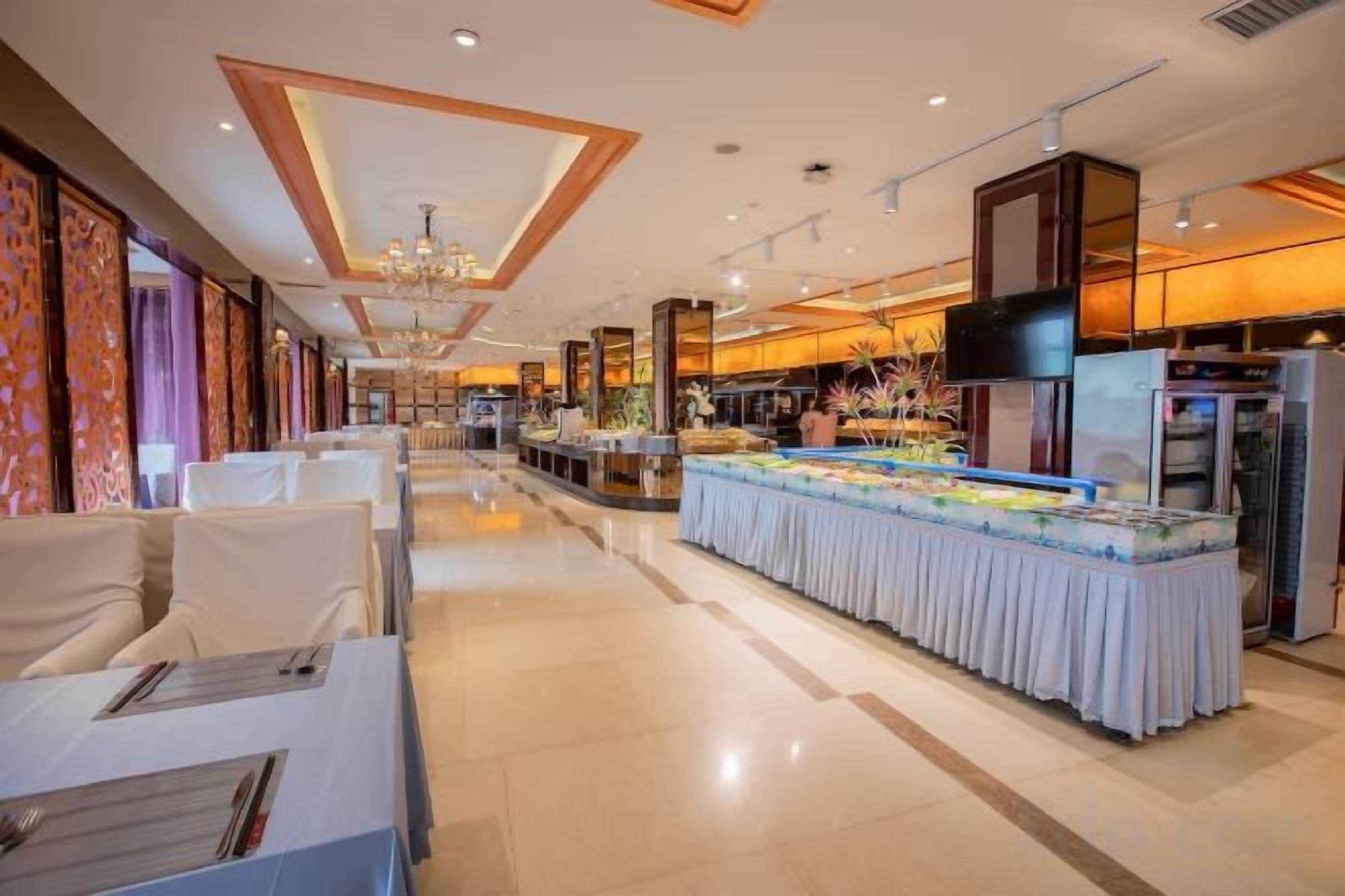 Un hall d’hôtel avec un buffet, un espace salon et un écran de télévision.