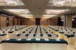 A conference room with rows of tables and chairs, a chandelier, and a traditional Asian-style wall. - Baiyun Hotel (West Building) (Lanzhou)