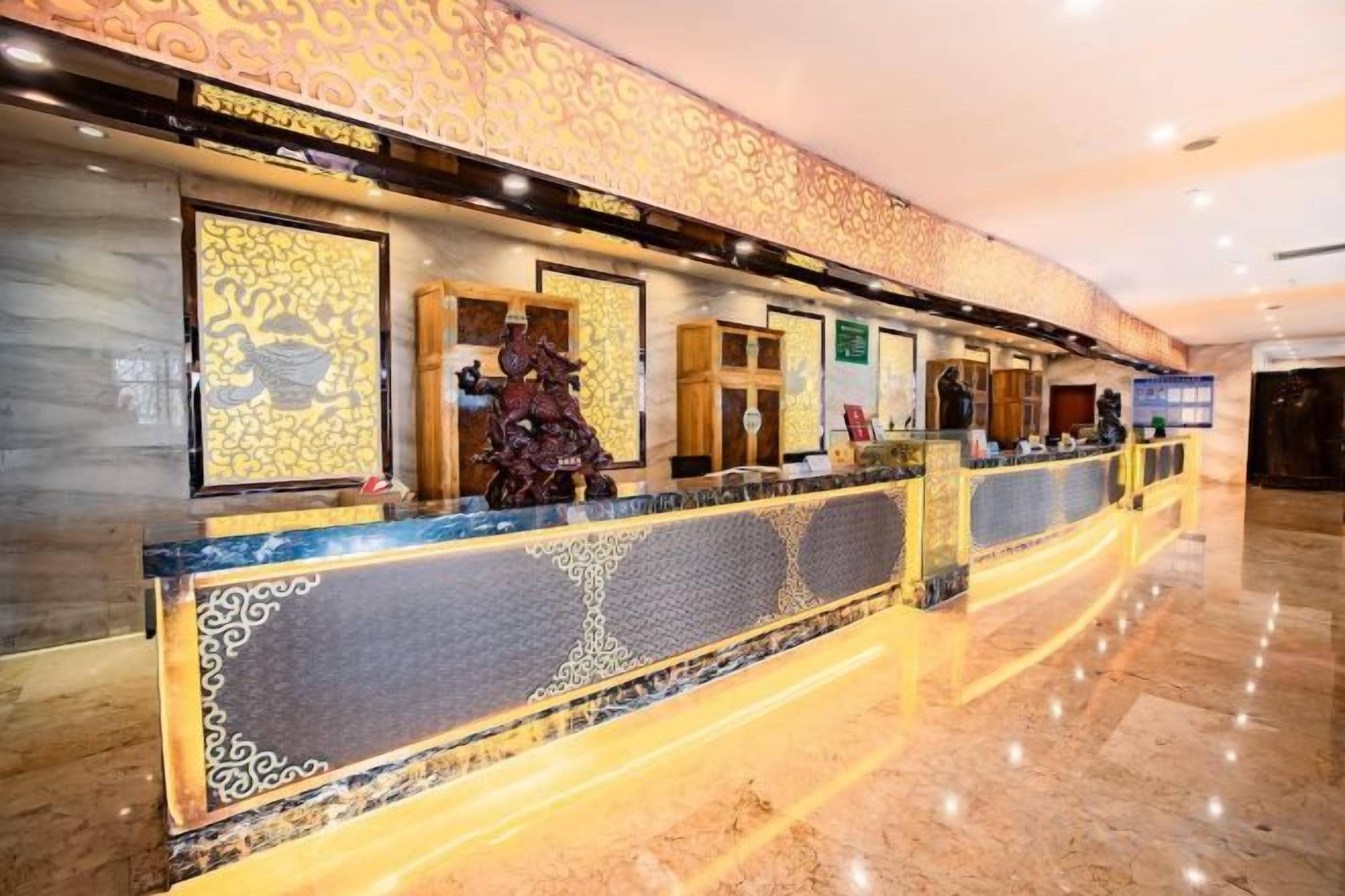 A reception area with a marble floor, a reception desk with a patterned design, and a wall with framed artwork.