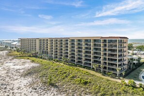 Un hôtel à plusieurs étages doté de balcons, situé près d’une plage.
