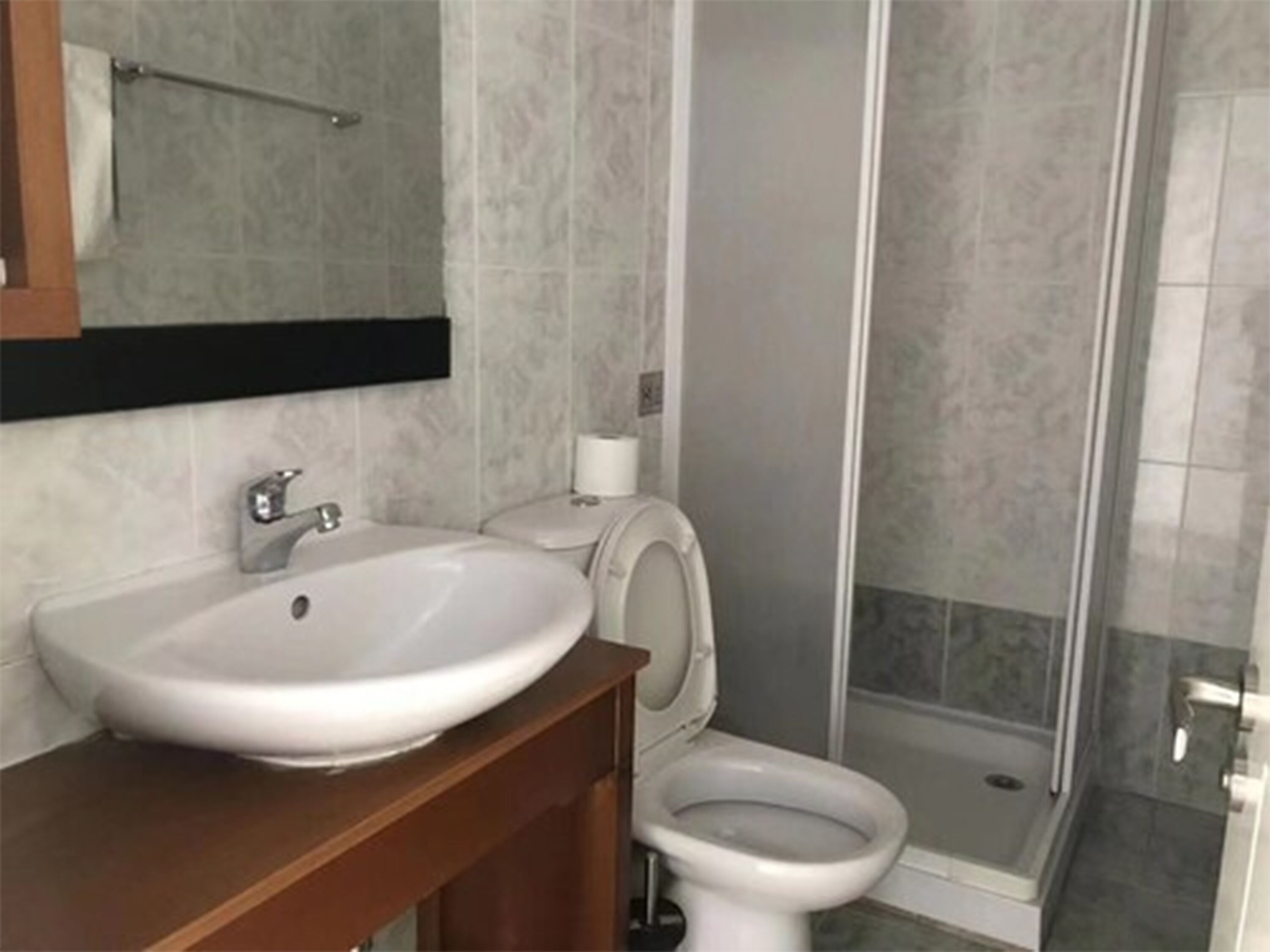 A bathroom with a sink, toilet, and shower.