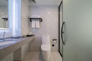 A modern bathroom with a marble sink, a toilet, and a glass shower enclosure. - Kaisheng Hotel (Xiangtan)