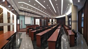 A conference room with long tables and chairs, a large screen, and a modern ceiling design. - Yaocheng Guesthouse (Dongzhi)