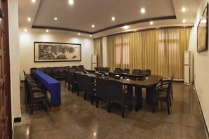 A conference room with a long table, chairs, a blue tablecloth, and a framed artwork on the wall. - Yaocheng Guesthouse (Dongzhi)