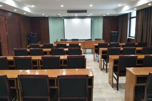 Un salón de conferencias con varias mesas y sillas dispuestas para reuniones.
