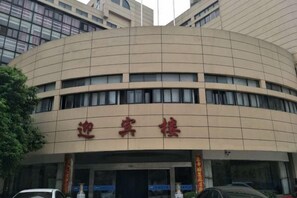 Un edificio con fachada curva y un letrero con caracteres chinos.