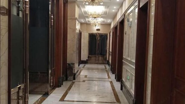 A long, narrow hallway with marble flooring and wooden doors. - Yaocheng Guesthouse (Dongzhi)