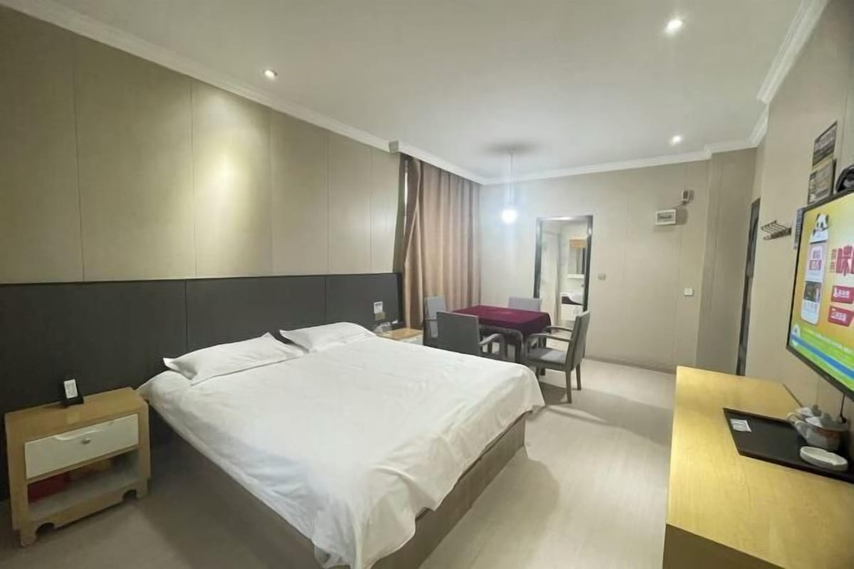 Ein Hotelzimmer mit Bett, Schreibtisch, Stuhl und Fernseher.