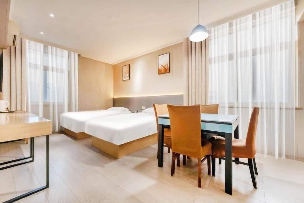 Ein Hotelzimmer mit einem Bett, einem Schreibtisch und einem Esstisch mit Stühlen.