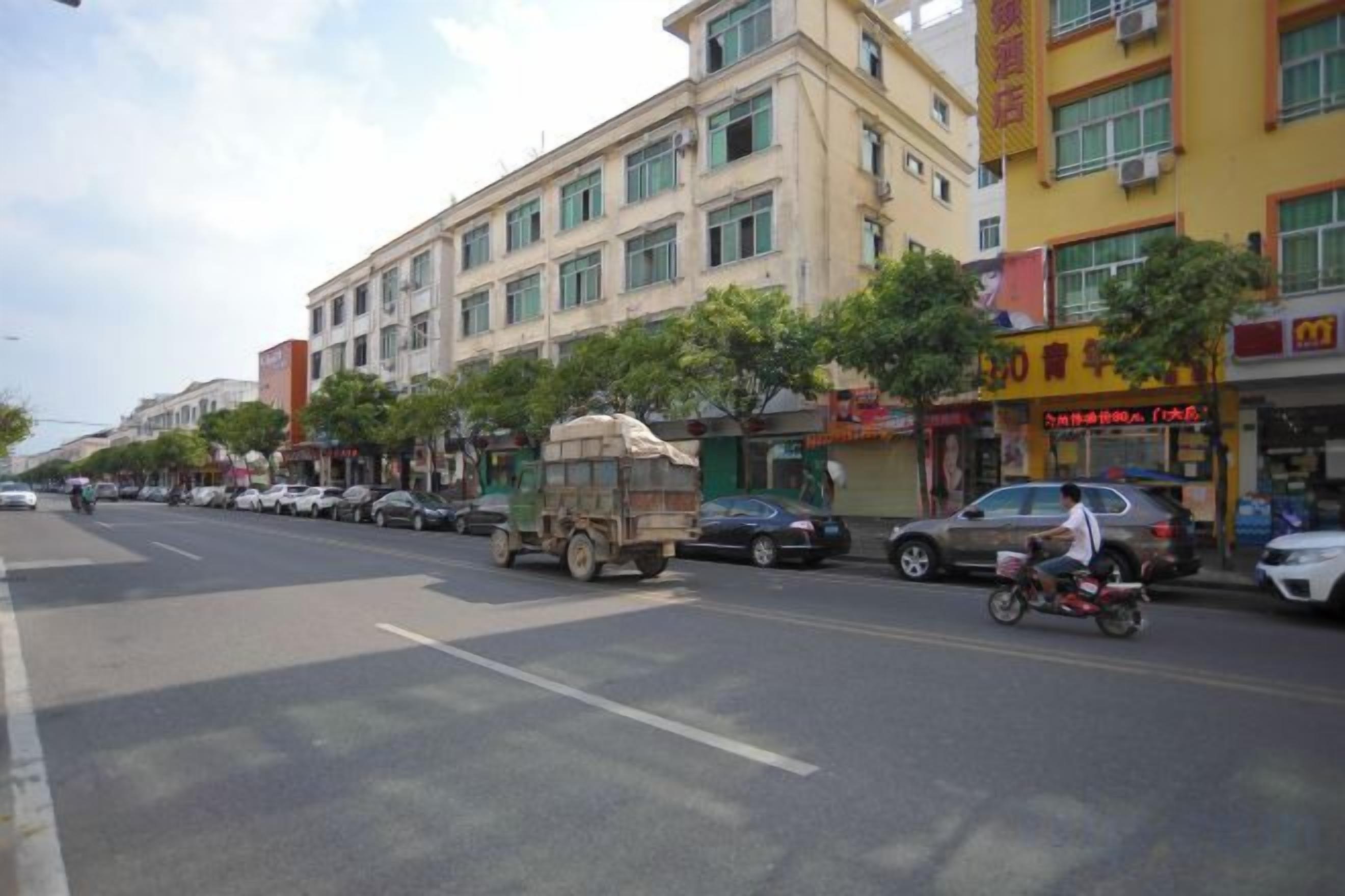 A street with buildings, a parked truck, and a motorcycle.