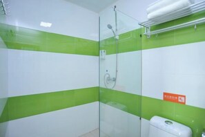 A bathroom with green and white tiles, a glass shower enclosure, and a toilet with a paper towel dispenser. - the 80youth Chain Hotel from Dongguan (Dongguan)