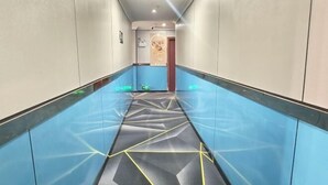 A hallway with a geometric patterned floor, white walls, and a door at the end. - the 80youth Chain Hotel from Dongguan (Dongguan)