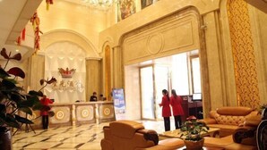 A lobby with a reception desk, seating area, and a chandelier. - Yijing Hotel (Zhongshan)