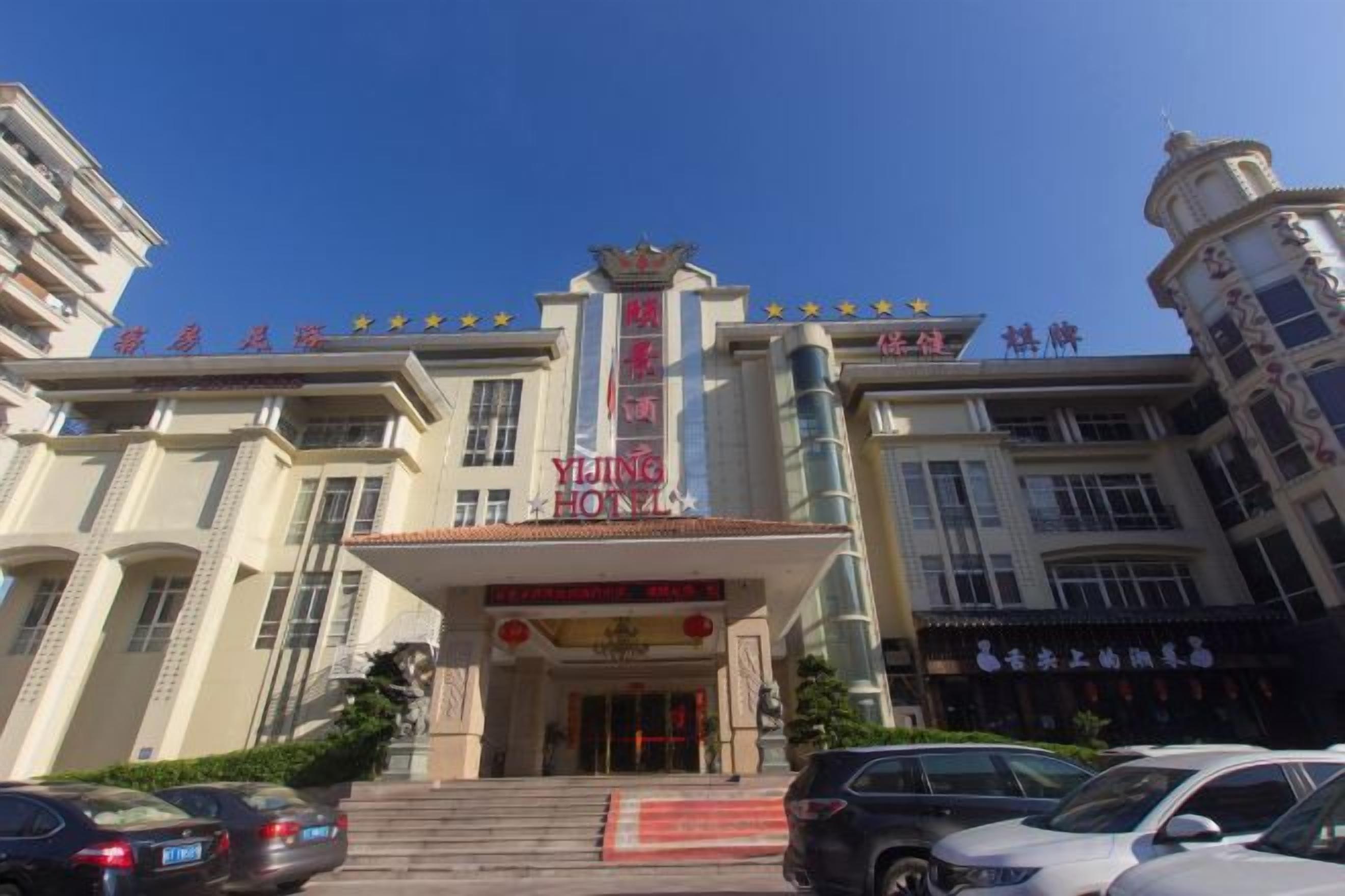 Un hôtel doté d’une entrée imposante, de plusieurs étages et offrant une vue sur un ciel dégagé.