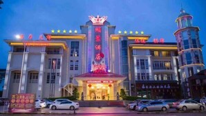 A hotel with a prominent sign, multiple floors, and a tower-like structure. - Yijing Hotel (Zhongshan)
