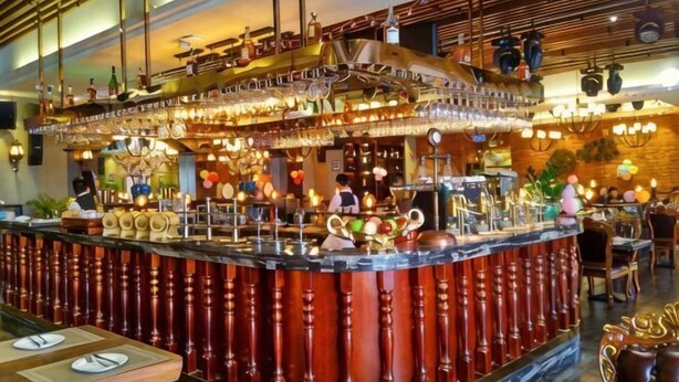 A bar area with a curved counter, bar stools, and a variety of bar tools and decorations. - Yijing Hotel (Zhongshan)
