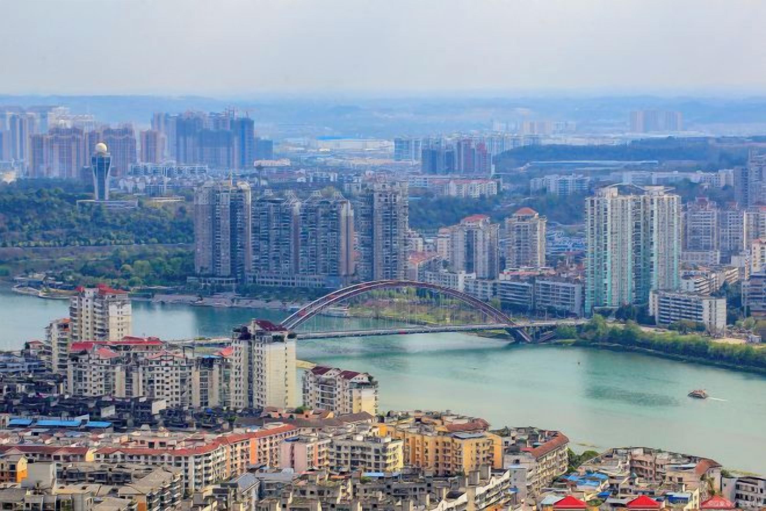 A cityscape with high-rise buildings, a river, and a bridge.