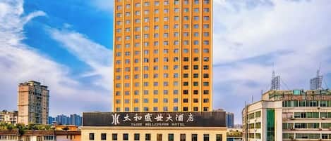 Un edificio de hotel alto con un letrero llamativo en la base.