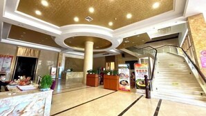 A spacious lobby with a marble reception desk, a staircase, and a ceiling with recessed lighting. - Jinxiu Xiangjiang Hotel (Foshan Jinsha) (Foshan)
