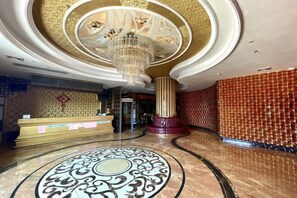 A luxurious lobby with a grand chandelier, a reception desk, and a patterned floor. - Jinxiu Xiangjiang Hotel (Foshan Jinsha) (Foshan)