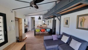 Un interior moderno con zona de comedor, sofá y ventilador de techo.