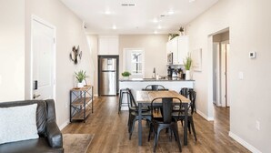A modern kitchen with a central island, stainless steel appliances, and a dining area with a wooden table and chairs. - Our Happy Place in the Heart of Branson (Branson)