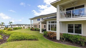 A modern multi-story residential building with a covered patio area, a well-maintained lawn, and a clear sky. - Na Hale O Keauhou Beach Views, Hot Tub & Pool (Kailua-Kona)