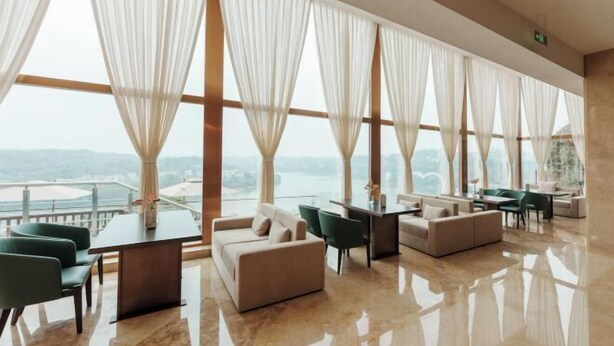 Una habitación amplia con un gran ventanal, una mesa de comedor y varios sofás.