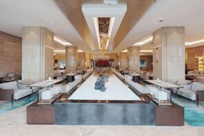 A spacious lobby with a central seating area, large pillars, and a modern chandelier. - Antai Yinshan Jinjiang Hotel (Wusheng)