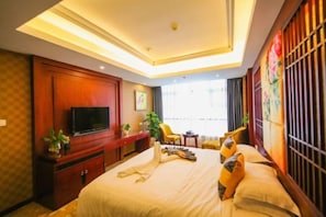A hotel room with a bed, a TV, a desk, and a window with curtains. - Antai Yinshan Jinjiang Hotel (Wusheng)
