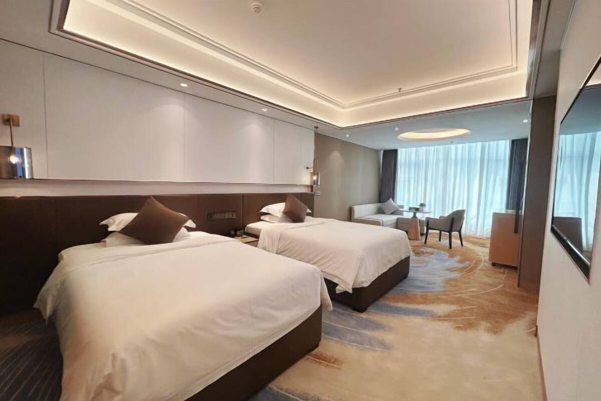 Una habitación de hotel con dos camas, un escritorio y una silla.