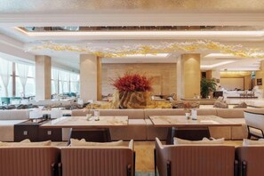 A spacious hotel lobby with a central reception desk, comfortable seating areas, and large windows providing natural light. - Antai Yinshan Jinjiang Hotel (Wusheng)