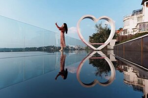 Una superficie reflectante con una estructura en forma de corazón y una persona de pie.