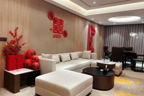 Una sala de estar moderna con un sofá seccional, una mesa de centro y elementos decorativos como faroles rojos y arte mural.