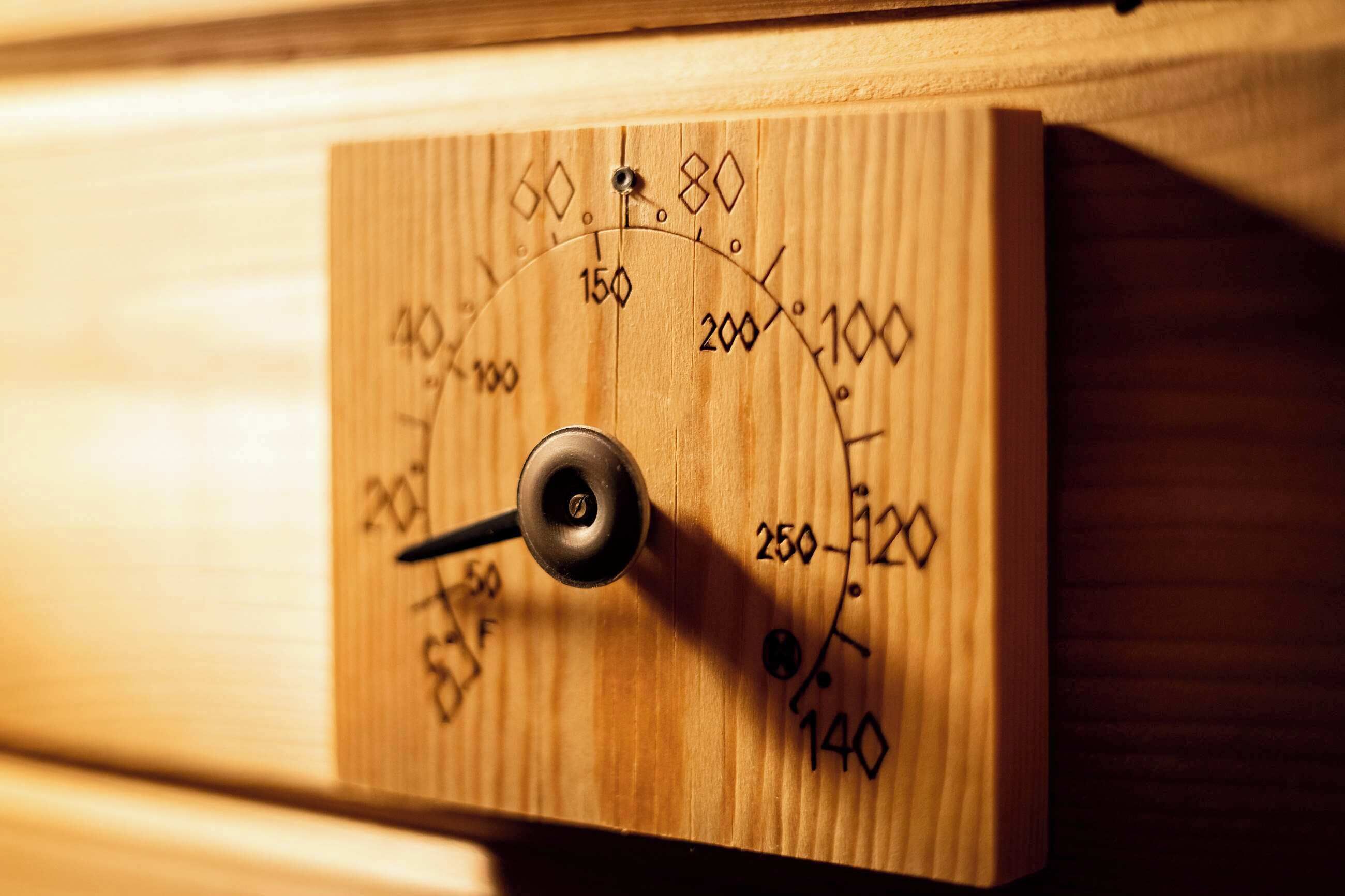 Ein Holzpaneel mit einem kreisförmigen Messgerät und einem Drehknopf, vermutlich Teil einer mechanischen Vorrichtung.