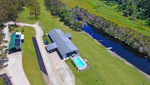 A large house with a swimming pool, a driveway, and a river nearby. - Rivers Edge: Experience a truly unique and serene holiday (Toorloo Arm)