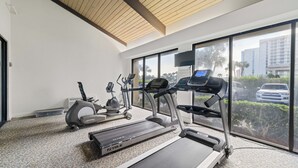A gym with treadmills, an elliptical, and a stationary bike. - White Caps 1102 by Liquid Life (Orange Beach)