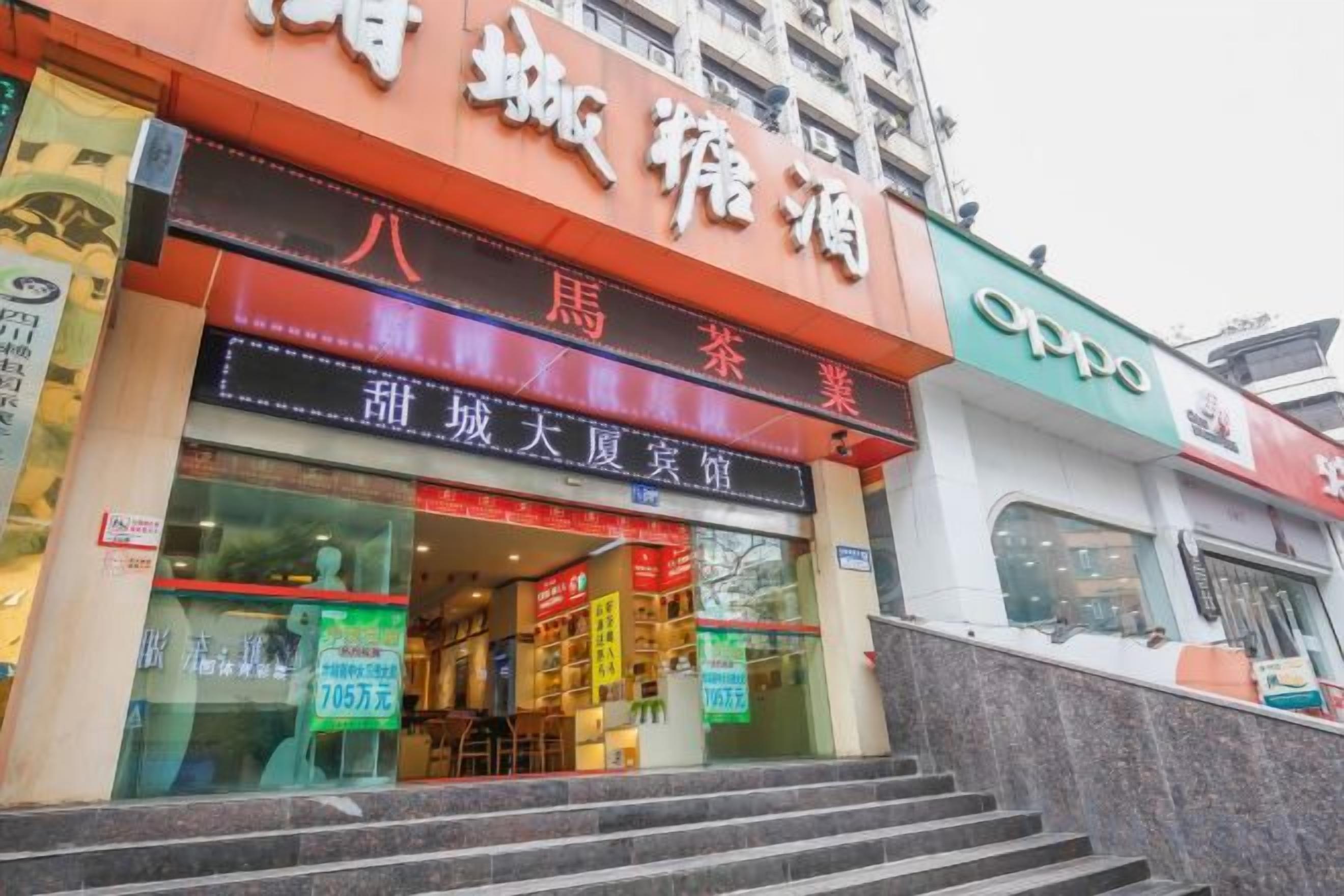 A building with a storefront featuring signage for a restaurant and a shop.