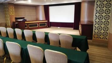 A conference room with a stage, rows of chairs, and a podium.