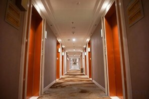 A long, narrow hotel corridor with doors on both sides, leading to individual rooms. - Tiancheng Plaza Hotel (Neijiang)