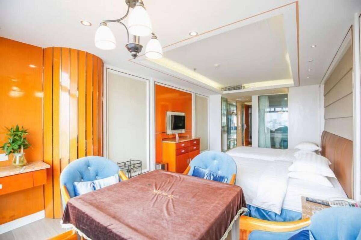 Ein Hotelzimmer mit einem Bett, einem Schreibtisch mit Stuhl, einem Fernseher und einem Fenster.