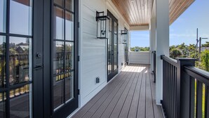 A covered porch with a wooden ceiling and a view of the surrounding area.