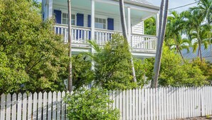 A white picket fence, a house with a balcony, and tropical vegetation. - Papa's Casita in Downtown Key West (Key West)