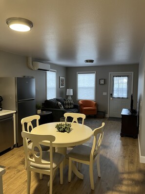 Un espace de vie compact comprenant une cuisine, un coin repas et un espace détente.